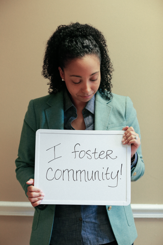 Dr. Mallery with a sign that says I foster community.